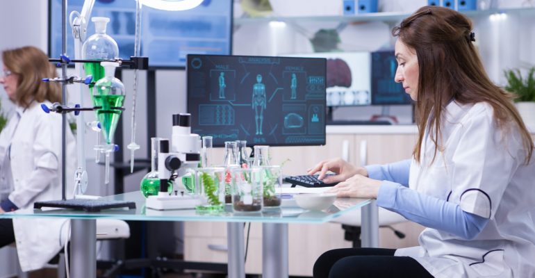 Female scientist typing on her computer the data from last scientific tests